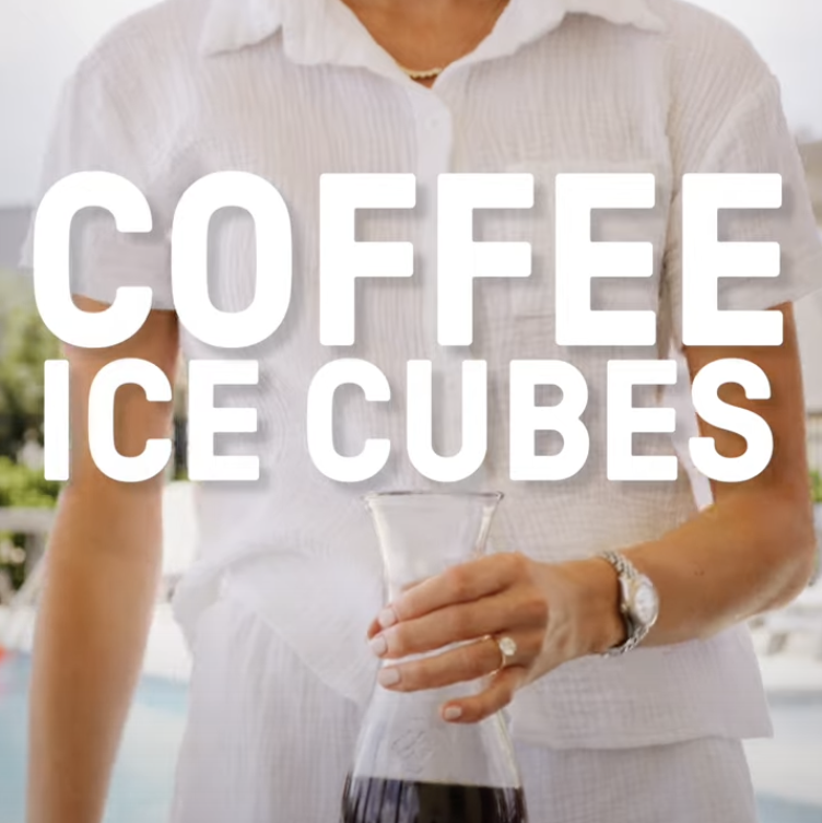 Person holding container of iced coffee with coffee ice cubes