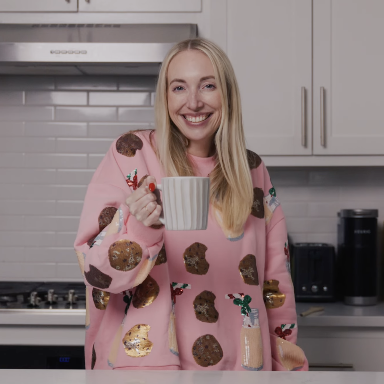 Woman holding mug of coffee in a kitchen